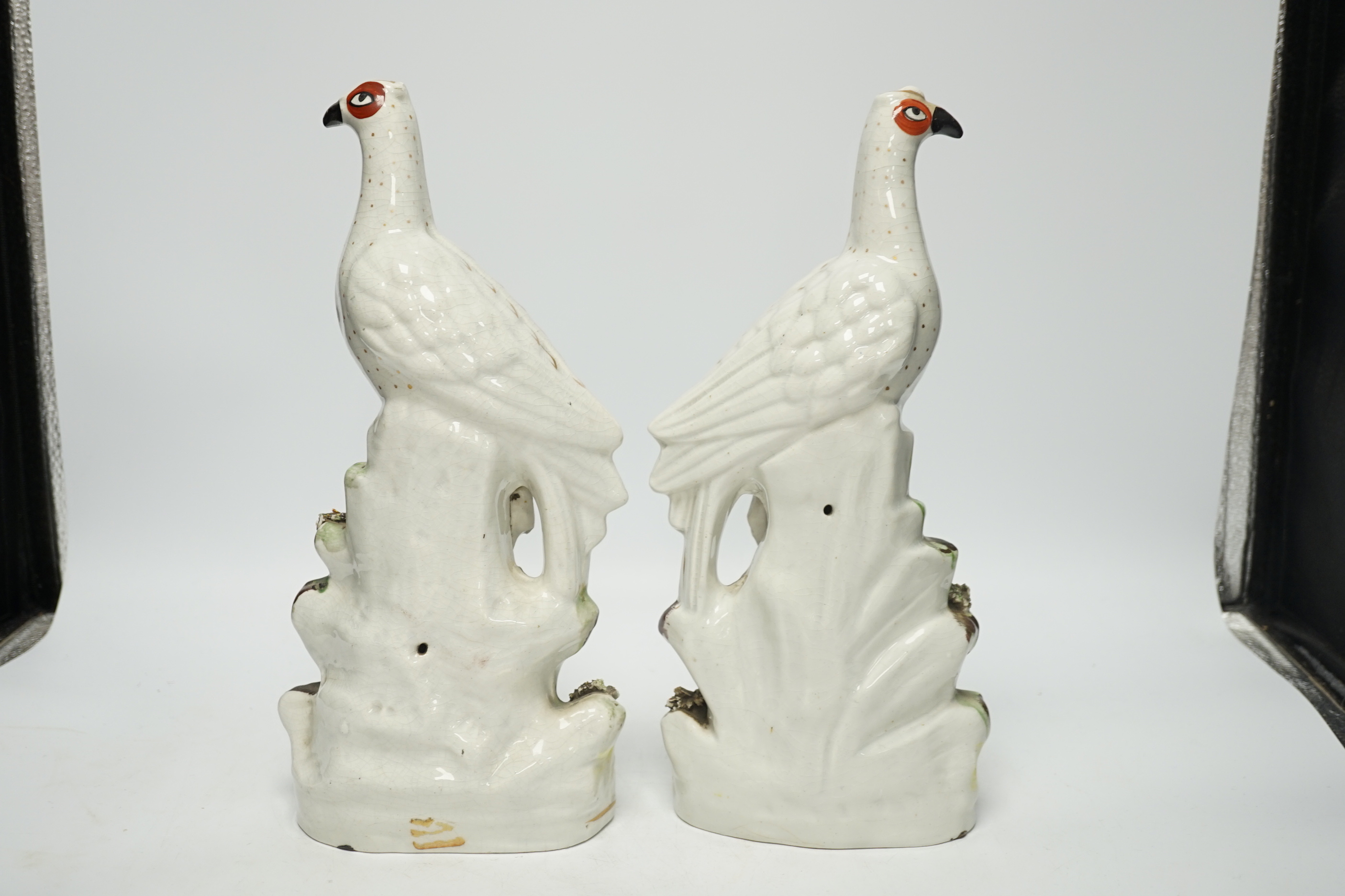 A pair of 19th century Staffordshire models of birds, each 32cm high